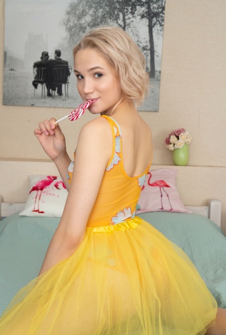 Cute blonde teen Melony holds a lollipop while making her nude debut