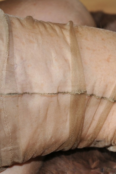 Older woman Nylon Sue struts her stuff wearing tan nylons and black lingerie