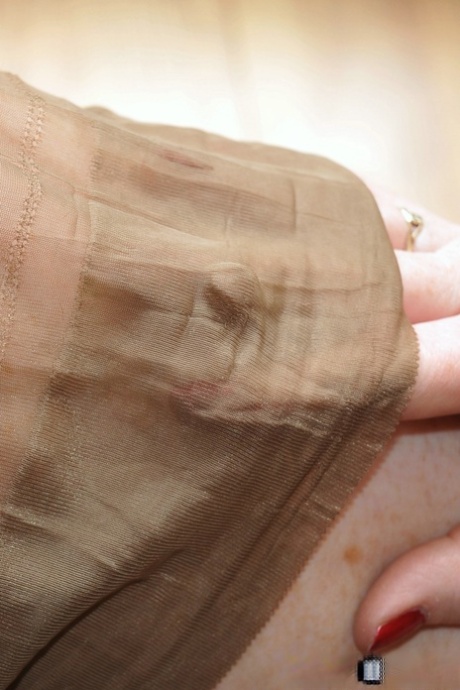 Older woman Nylon Sue struts her stuff wearing tan nylons and black lingerie