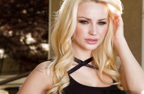 Top rated blonde babe Staci Carr posing on motorcycle in black dress